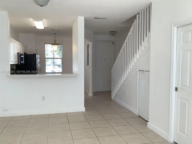 a view of a kitchen with an empty space and a window