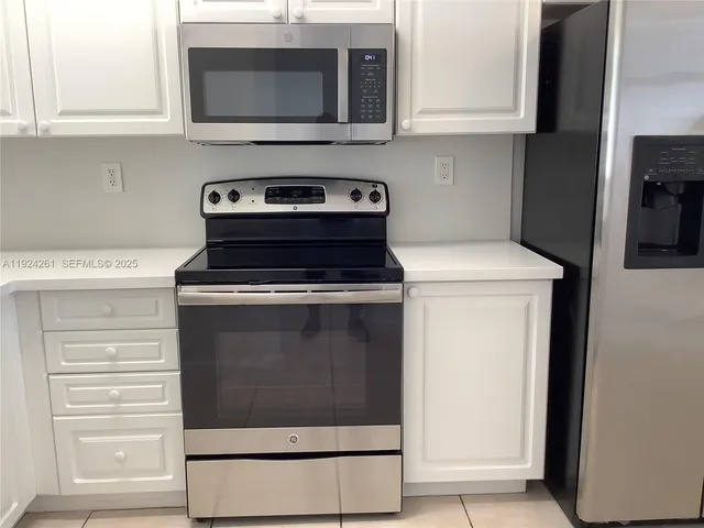 a kitchen with microwave cabinets and stove top oven