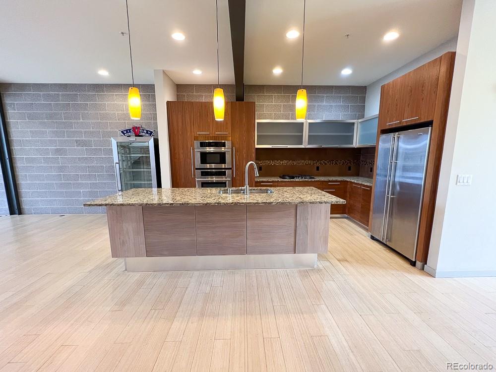 11570 Colony Row Broomfield, CO 80021 - Photo 8 of 24 a large kitchen with stainless steel appliances a large counter top a stove and a refrigerator