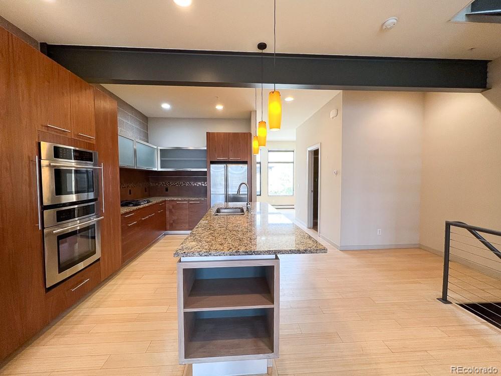 11570 Colony Row Broomfield, CO 80021 - Photo 10 of 24 a kitchen with stainless steel appliances kitchen island a large counter top space and cabinets