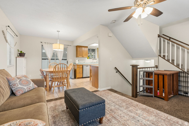 1099 South 950 East, Unit 17 Provo, UT 84606 - Photo 6 of 23 Open-concept living area featuring a ceiling fan, light carpet and tile flooring, and a staircase with white balusters