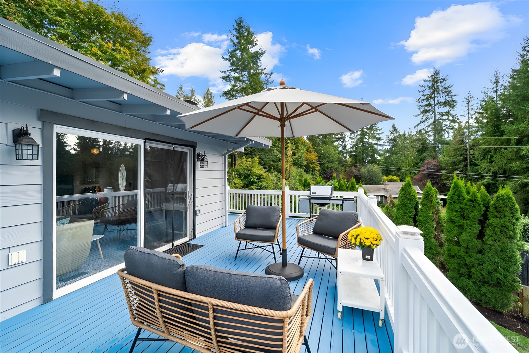 18308 Southeast 145th Street Renton, WA 98059 - Photo 2 of 26 a view of a patio with table and chairs under an umbrella with wooden floor and fence