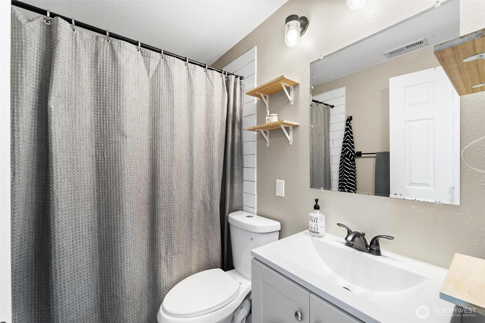 18308 Southeast 145th Street Renton, WA 98059 - Photo 8 of 26 a bathroom with a sink a toilet and shower curtain