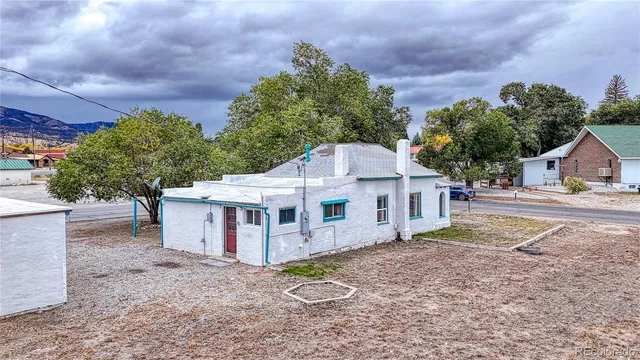 a white house that has a tree in front of it
