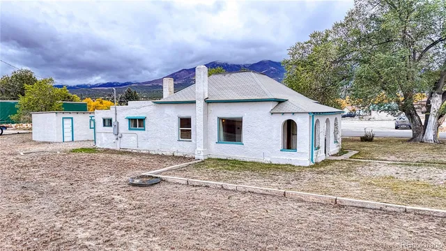 a view of a house with a yard and large tree