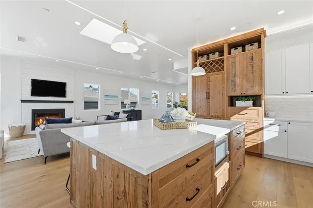 a large kitchen with kitchen island a stove a sink a center island and furniture