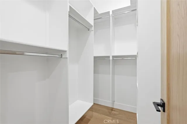 a view of walk in closet with empty racks