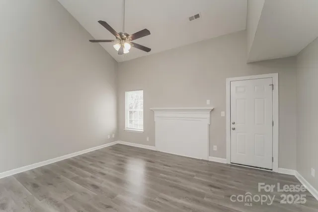 a view of a livingroom with a ceiling fan and wooden floor