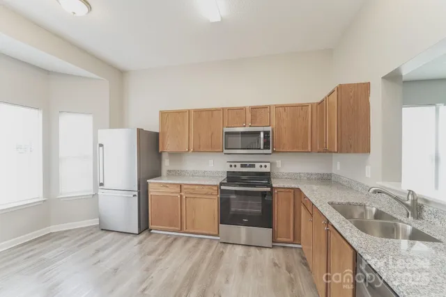 a kitchen with stainless steel appliances granite countertop a refrigerator stove and sink