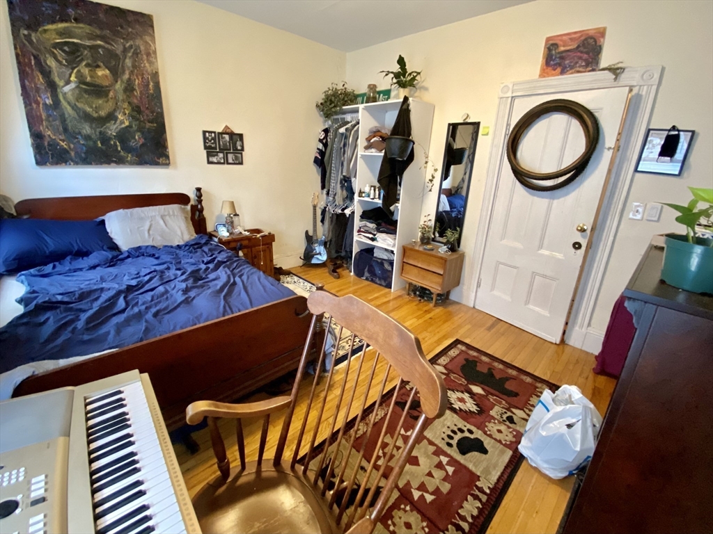 3 Oswald Street, Unit 3 Boston, MA 02120 - Photo 17 of 23 a bed sitting in a bedroom next to a small yard