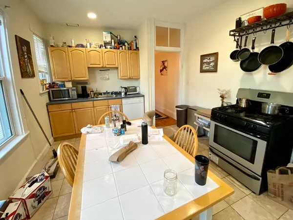 a kitchen with stainless steel appliances kitchen island granite countertop a table and a couch