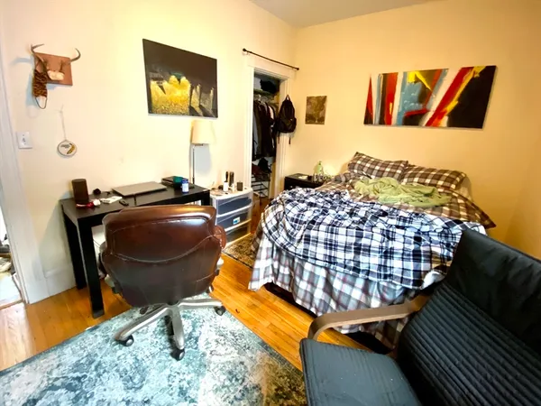 a living room with a couch and dresser with wooden floor