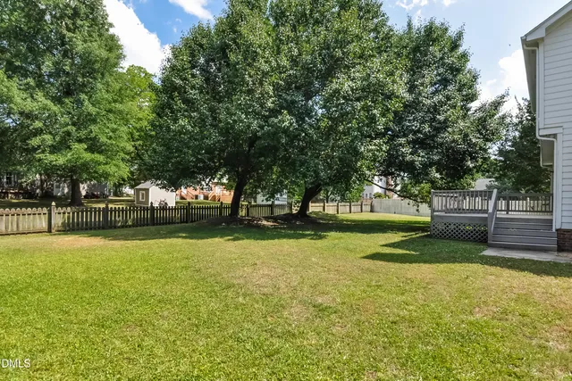 a view of swimming pool with trees and wooden fence