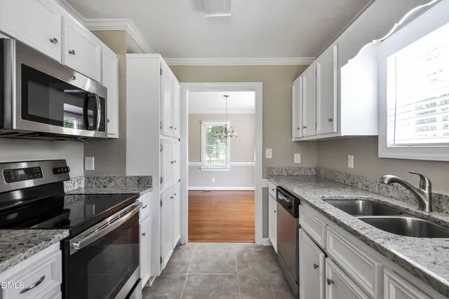 a kitchen with granite countertop cabinets stainless steel appliances and a window