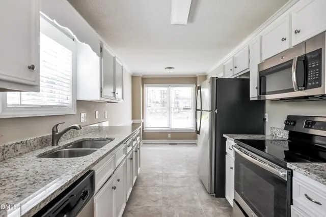 a kitchen with stainless steel appliances granite countertop a sink stove and refrigerator