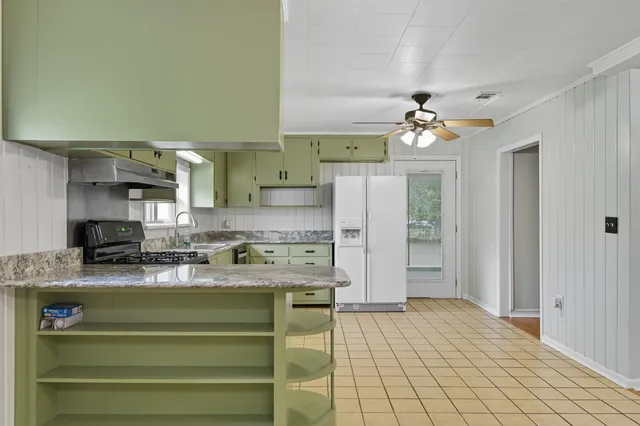 a kitchen with stainless steel appliances granite countertop a white cabinets and a stove top oven