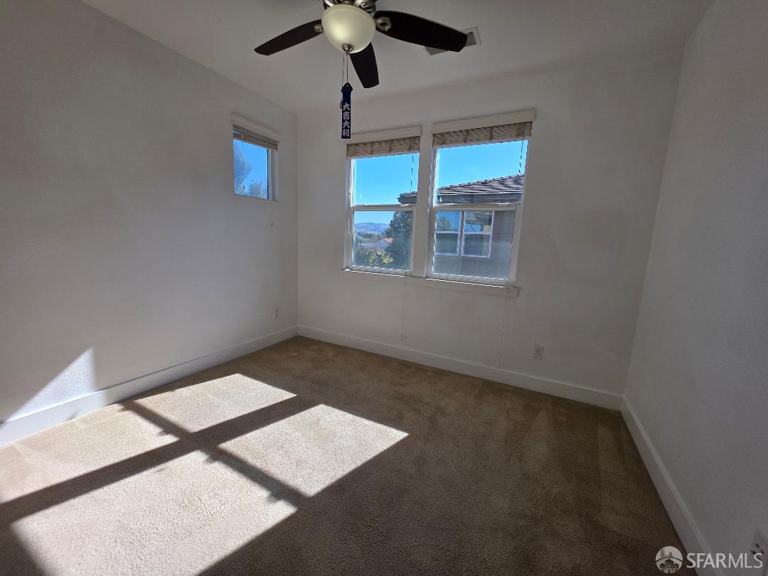 2415 Stearman Court, Unit 7 San Jose, CA 95132 - Photo 12 of 13 en empty room with windows and ceiling fan