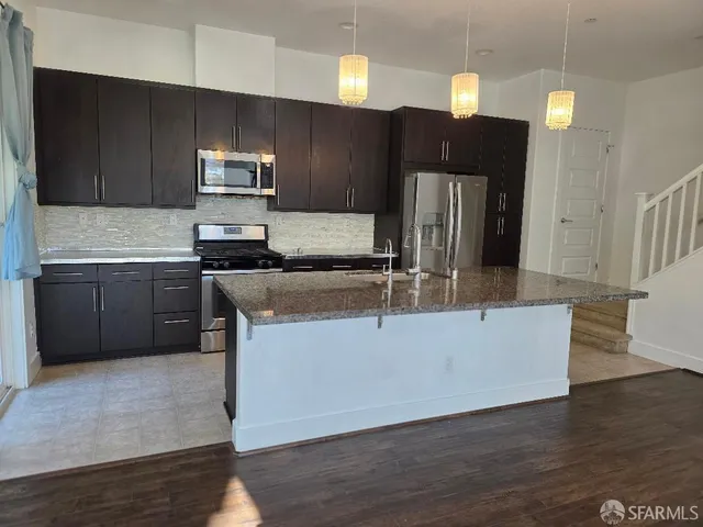 a kitchen with stainless steel appliances granite countertop a stove a sink and a refrigerator