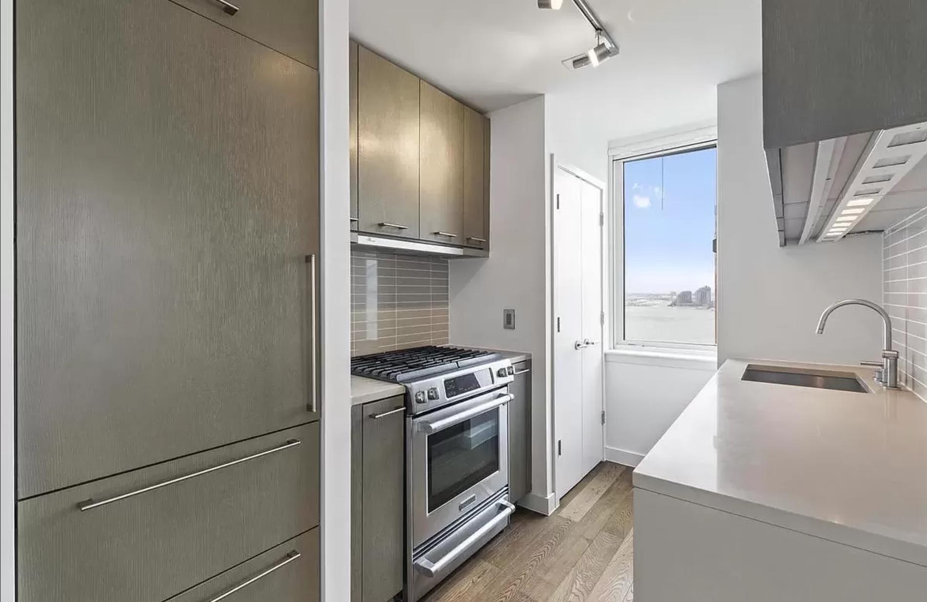 225 Rector Place, Unit 22H Manhattan, NY 10280 - Photo 5 of 13 a kitchen with a stove and a refrigerator