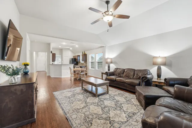 a living room with furniture and a wooden floor