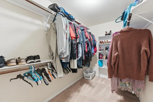 a view of walk in closet with clothes and shoes