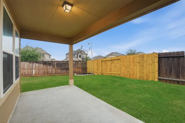 a view of a backyard with wooden fence