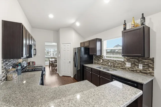 a kitchen with stainless steel appliances granite countertop a sink stove and refrigerator