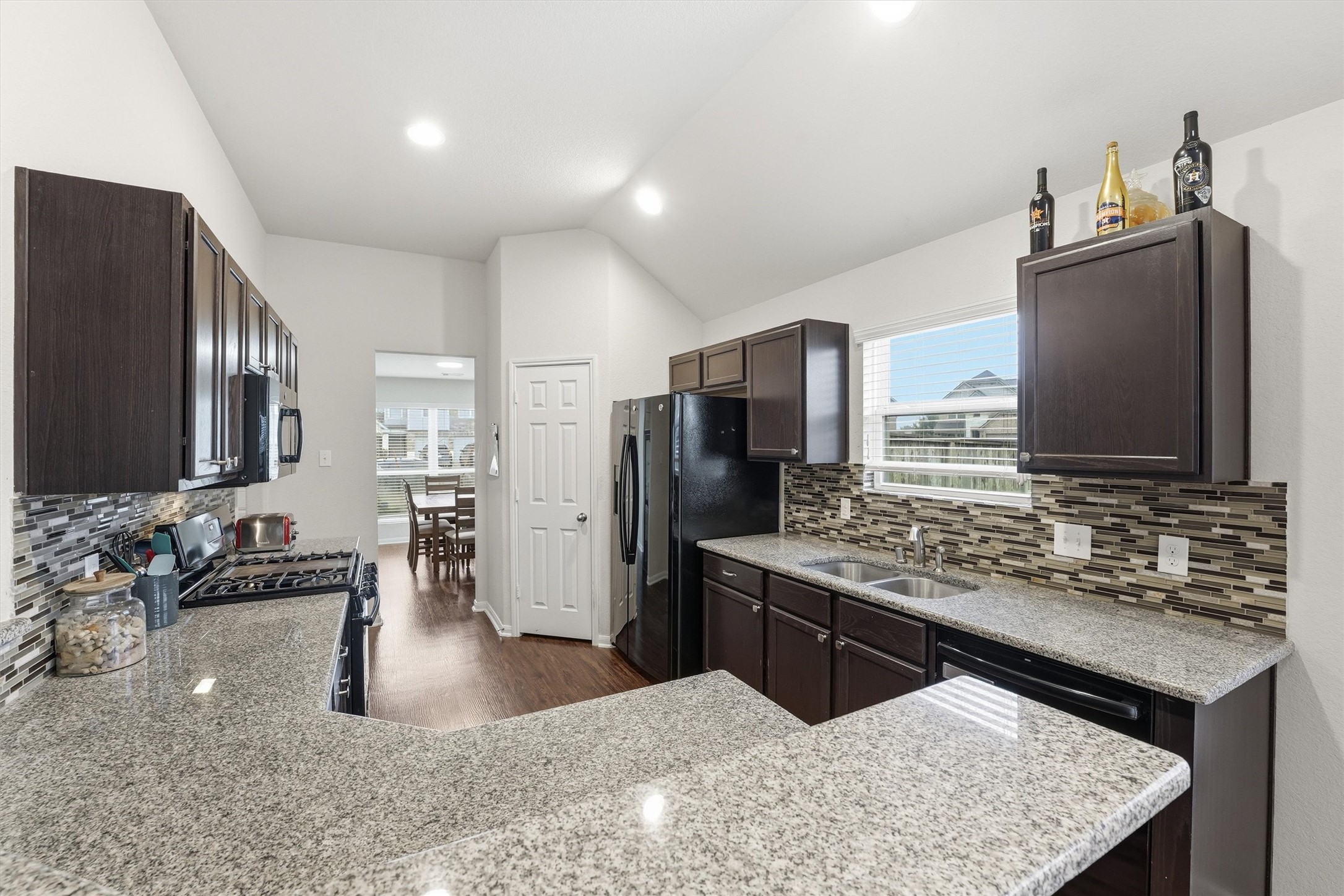 2115 Pacific Loon Lane Conroe, TX 77385 - Photo 9 of 26 a kitchen with stainless steel appliances granite countertop a sink stove and refrigerator