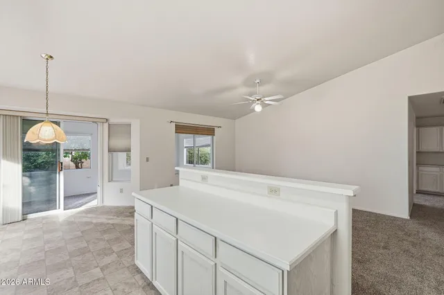 a room with a bed and ceiling fan