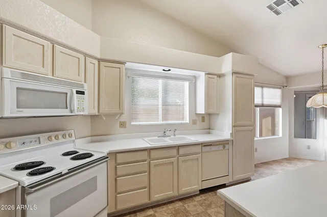 a kitchen with granite countertop white cabinets and white appliances