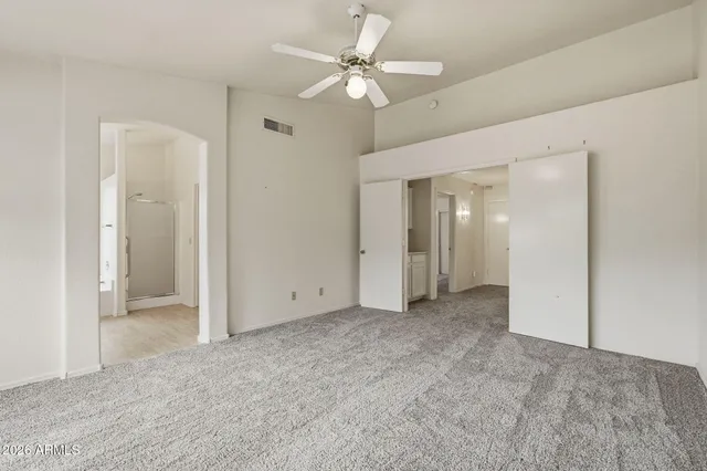 an empty room with fan and entryway