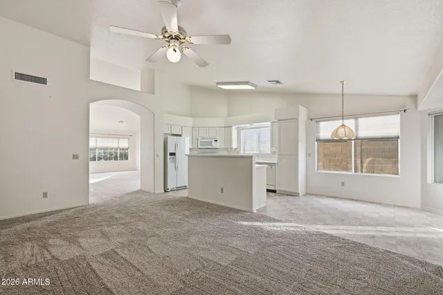 a view of a kitchen with an empty space and a ceiling fan