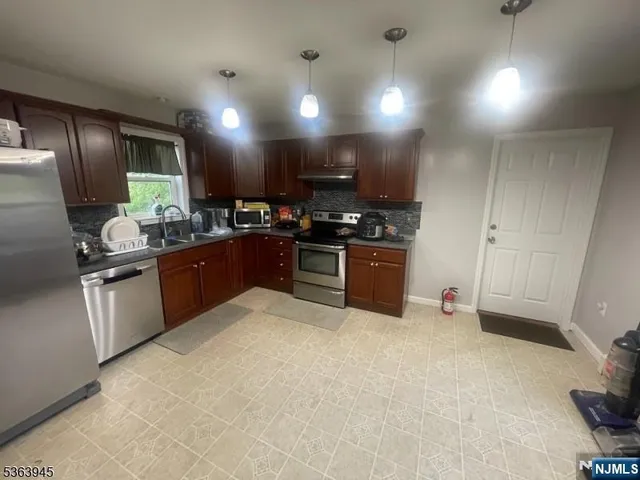 a kitchen with stainless steel appliances granite countertop a stove a sink and a refrigerator