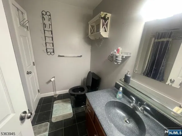 a bathroom with a sink and mirror with toilet