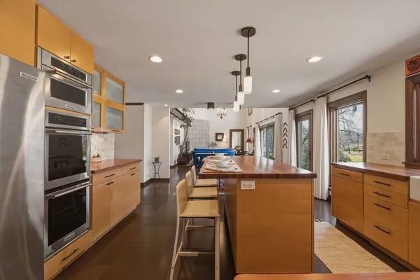 a kitchen with kitchen island a counter top space a sink stainless steel appliances and cabinets
