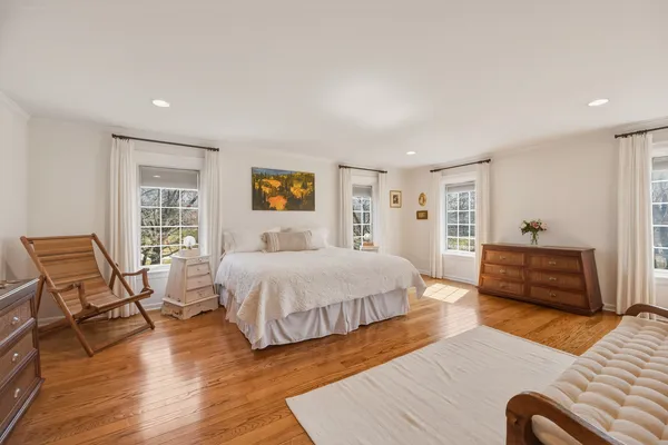 a spacious bedroom with a bed and wooden floor