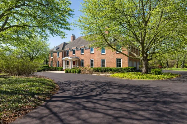 a front view of a house with a yard and shrubs