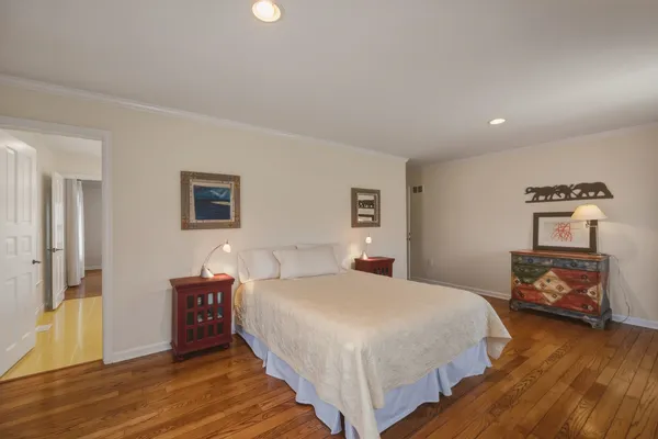 a bedroom with a bed and a wooden floor