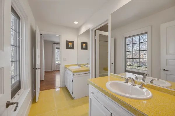 a spacious bathroom with a tub sink and mirror