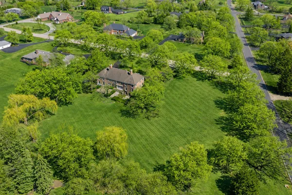 an aerial view of residential house with outdoor space and trees all around