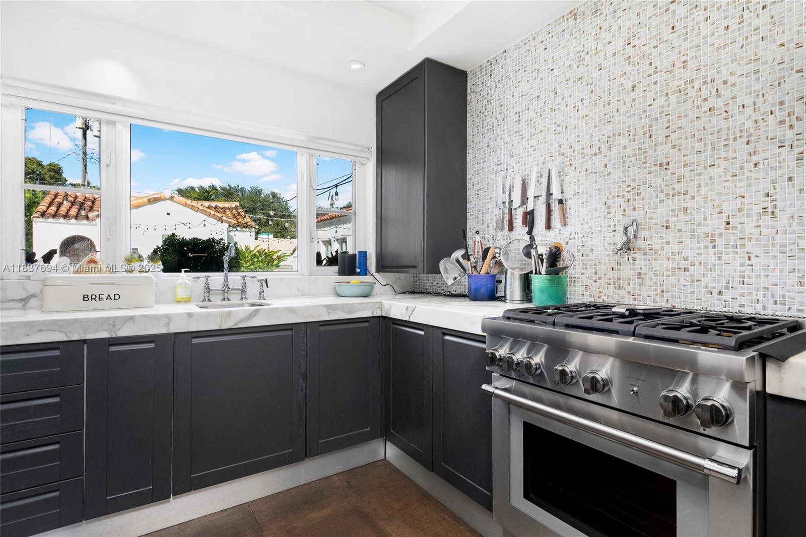 113 Northeast 101st Street Miami Shores, FL 33138 - Photo 12 of 56 a kitchen with stainless steel appliances a sink stove and cabinets