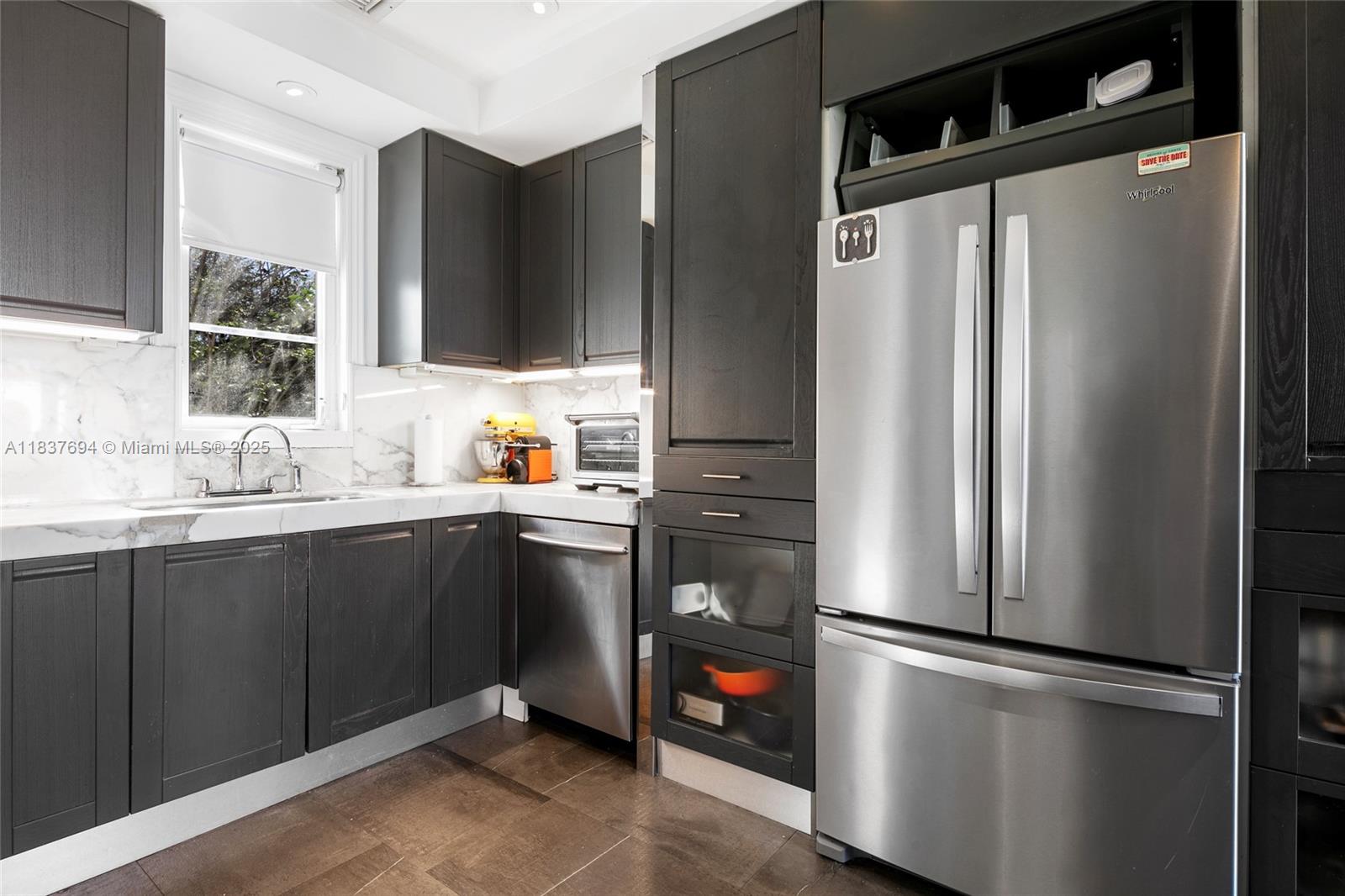113 Northeast 101st Street Miami Shores, FL 33138 - Photo 13 of 56 a kitchen with stainless steel appliances a refrigerator and a sink