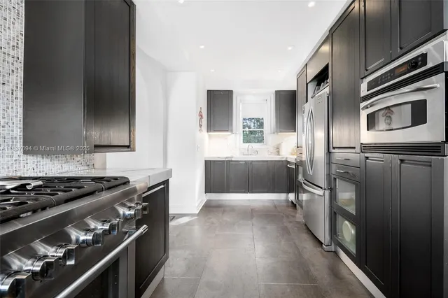 a kitchen with stainless steel appliances a refrigerator sink and stove