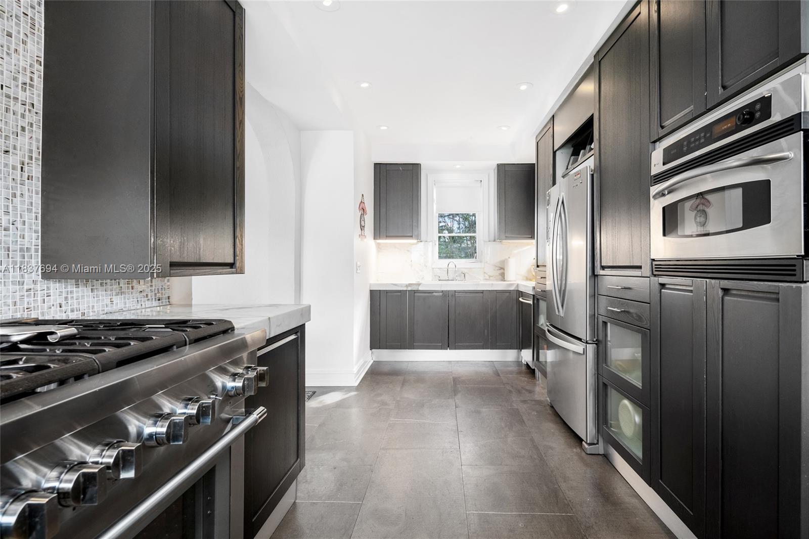 113 Northeast 101st Street Miami Shores, FL 33138 - Photo 15 of 56 a kitchen with stainless steel appliances granite countertop a stove and a refrigerator