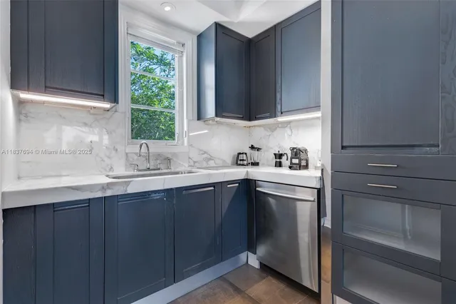 a kitchen with kitchen island granite countertop a sink stove and cabinets