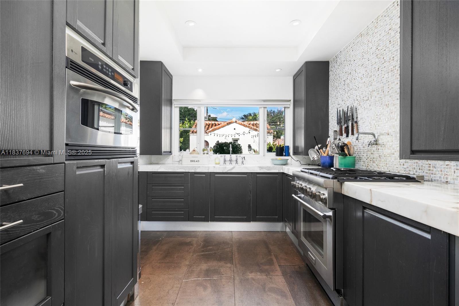 113 Northeast 101st Street Miami Shores, FL 33138 - Photo 18 of 56 a kitchen with kitchen island granite countertop a sink stove and cabinets