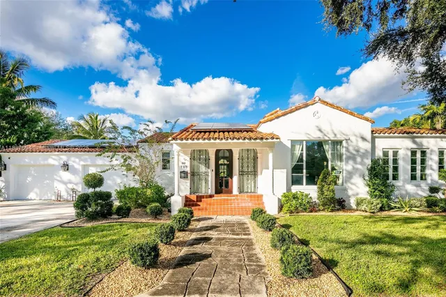 a view of a house with a yard and a garage