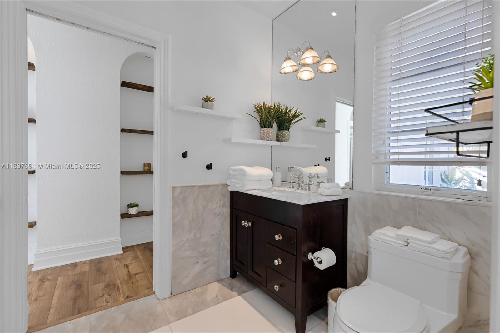 113 Northeast 101st Street Miami Shores, FL 33138 - Photo 27 of 56 a bathroom with a toilet a sink and a mirror