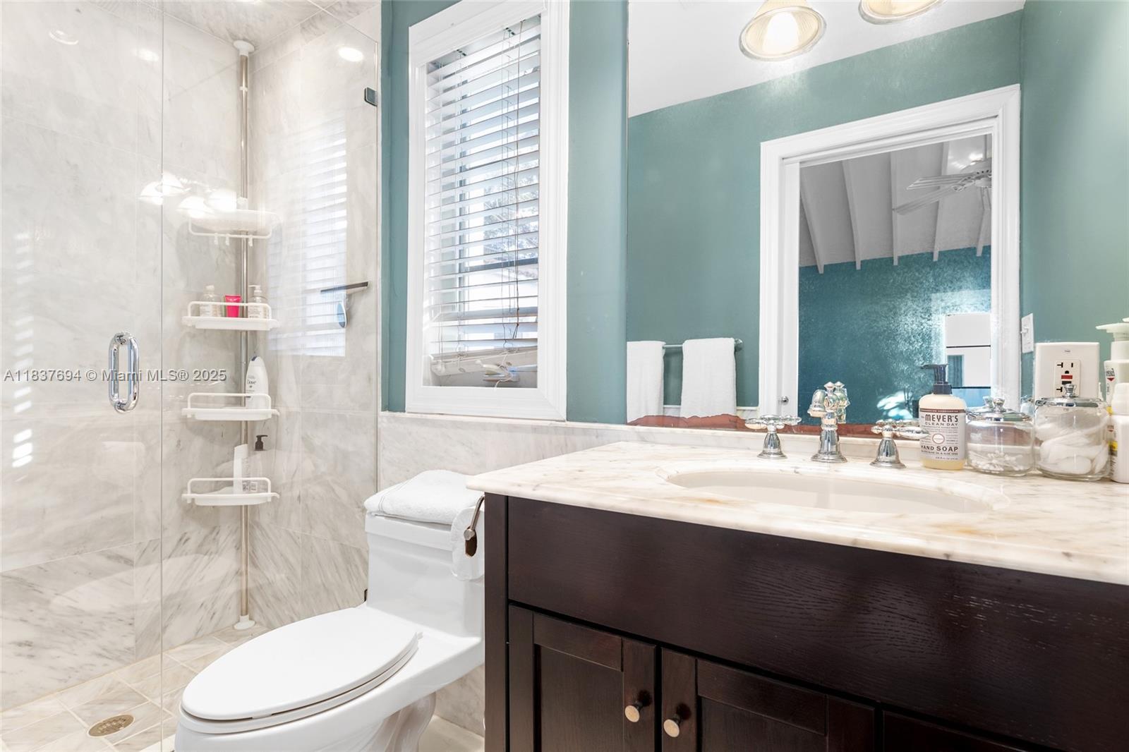 113 Northeast 101st Street Miami Shores, FL 33138 - Photo 33 of 56 a bathroom with a granite countertop sink toilet a mirror and shower
