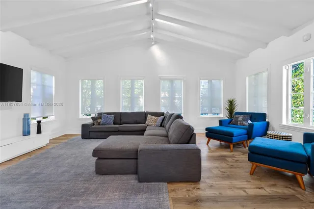 a view of a room with wooden floor table and chairs